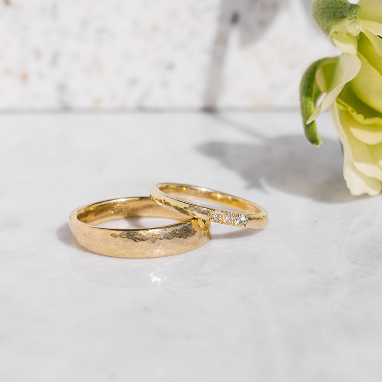Schmale goldene Eheringe mit Hammerschlag und Brillanten im Damenring
