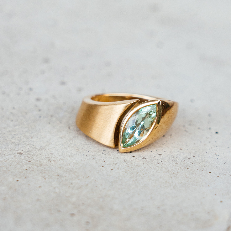 goldener Ring mit blau grünem Stein in Navette-Form