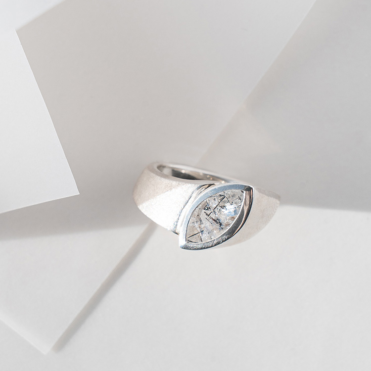 Ergonomischer Ring aus Silber mit matt strukturierter Oberfläche und großem Rutilquarz im Navette Schliff