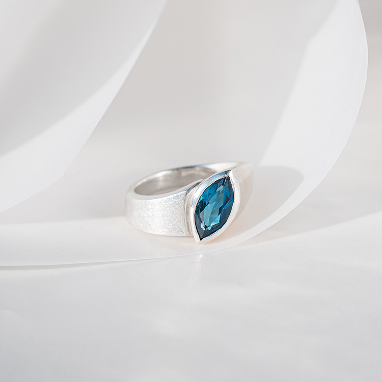 Ergonomischer Ring aus Silber mit matt strukturierter Oberfläche und großem Topas im Navette Schliff