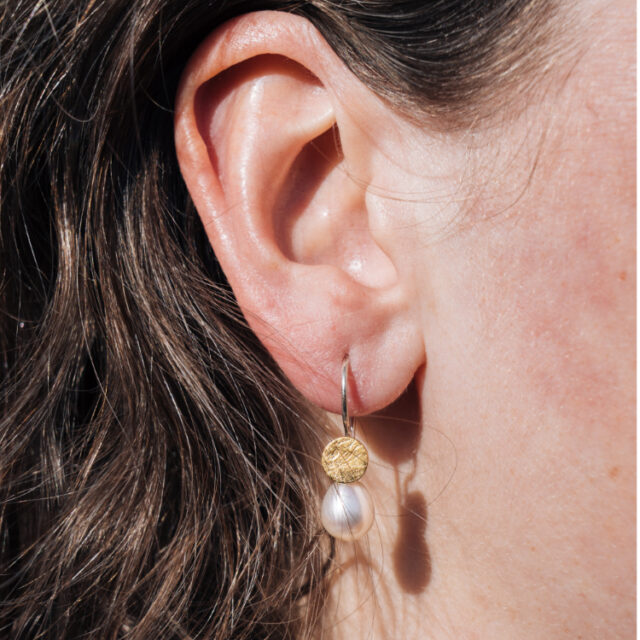 Ohrhänger am Ohr mit Perle und Gold
