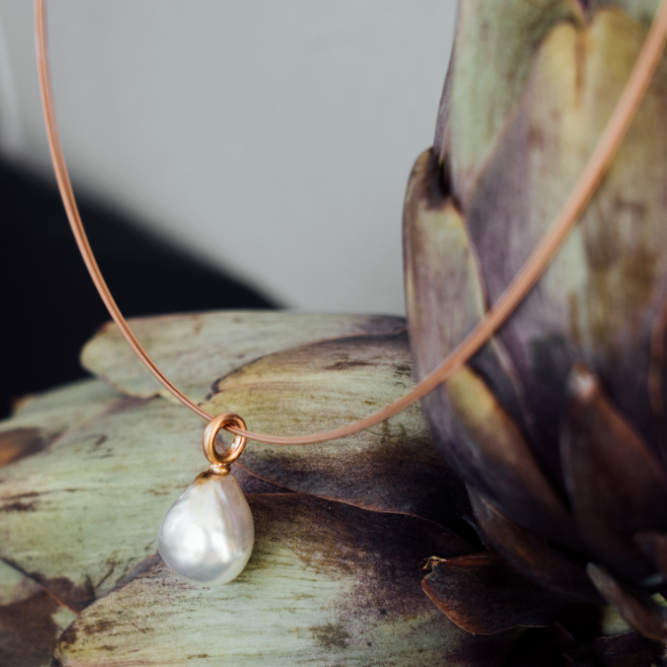 Anhänger mit einer Perle in Naturform auf Artischocken fotografiert