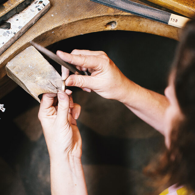 Schmuckwerkstatt, ein Trauring wird gefeilt.