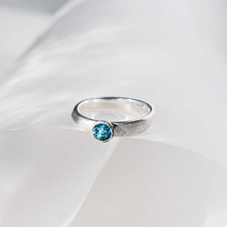 Ergonomischer Silberring mit leuchtend blauem Stein und matt strukturierter Oberfläche