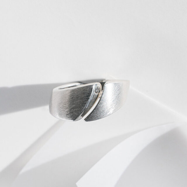 Ergonomischer Silberring mit besonderer Form und Spalt. Besetzt mit einem kleinen Brillanten