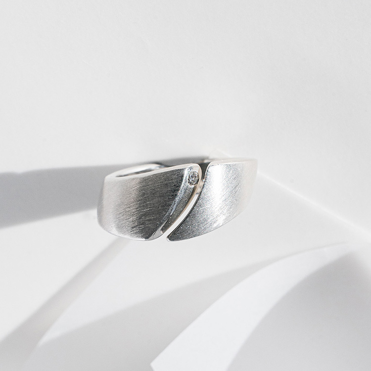 Ergonomischer Silberring mit besonderer Form und Spalt. Besetzt mit einem kleinen Brillanten