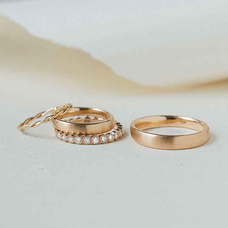 4 goldene Ringe, ein Herrenring und drei Damenringe, die gemeinsam getragen werden können. Einer mit Brillanten