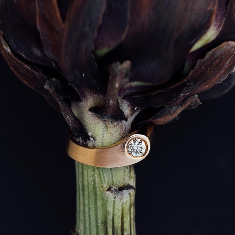 Goldener Ring in Roségold mit naturfarbenem Brillanten auf einer Artischocke. Matte Oberfläche