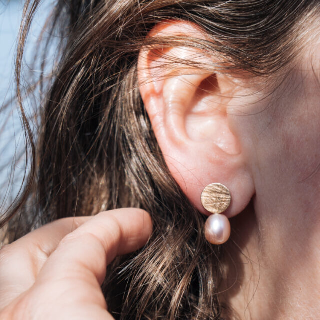 Perlenohrstecker am Ohr mit rosa Perle und Roségold