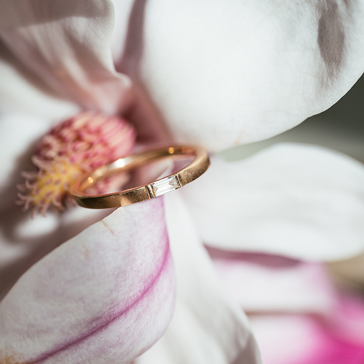 Ring in Roségold mit braunem Diamanten im Baguette-Schliff mit matter Oberfläche auf einer Magnolien-Blüte