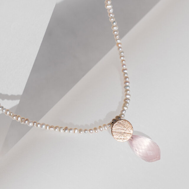Kette aus weißen Perlen mit Anhänger aus Roségold mit aufgewalzter Struktur und facettiertem Rosenquarz