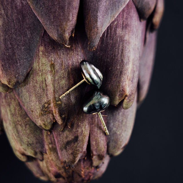 Ohrstecker mit schwarzen Tahiti-Keshi-Zuchtperlen mit Gelbgold auf einer Artischoke