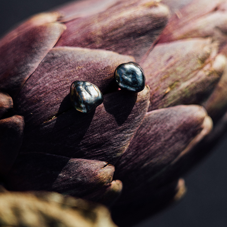 Ohrstecker mit schwarzen Tahiti-Keshi-Zuchtperlen mit Gelbgold auf einer Artischoke