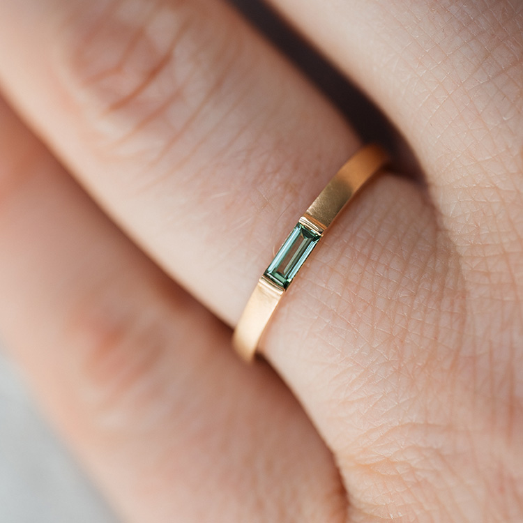 Schmaler Bandring in gold mit grünem Diamant im Baguette Schliff