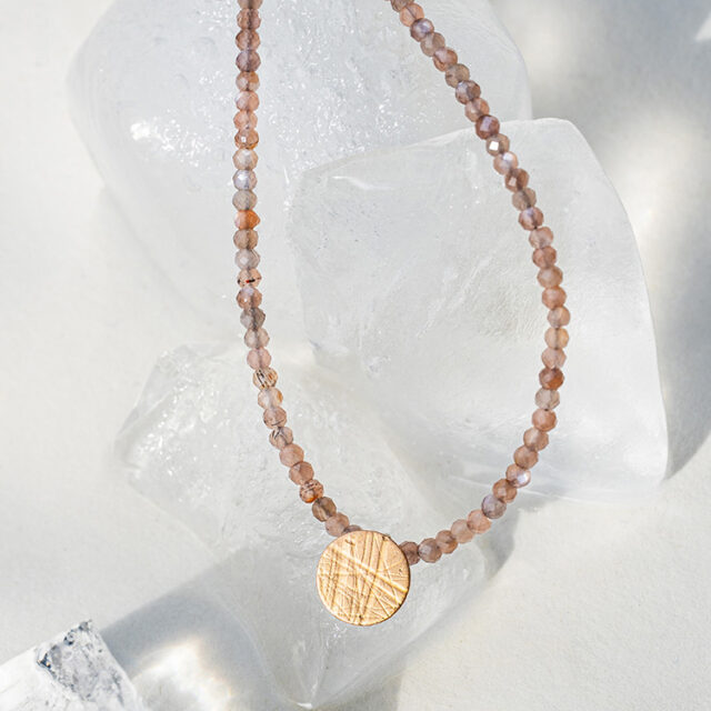 Kette mit Punkt Element aus Silber mit Roségold mit aufgewalzter Struktur.