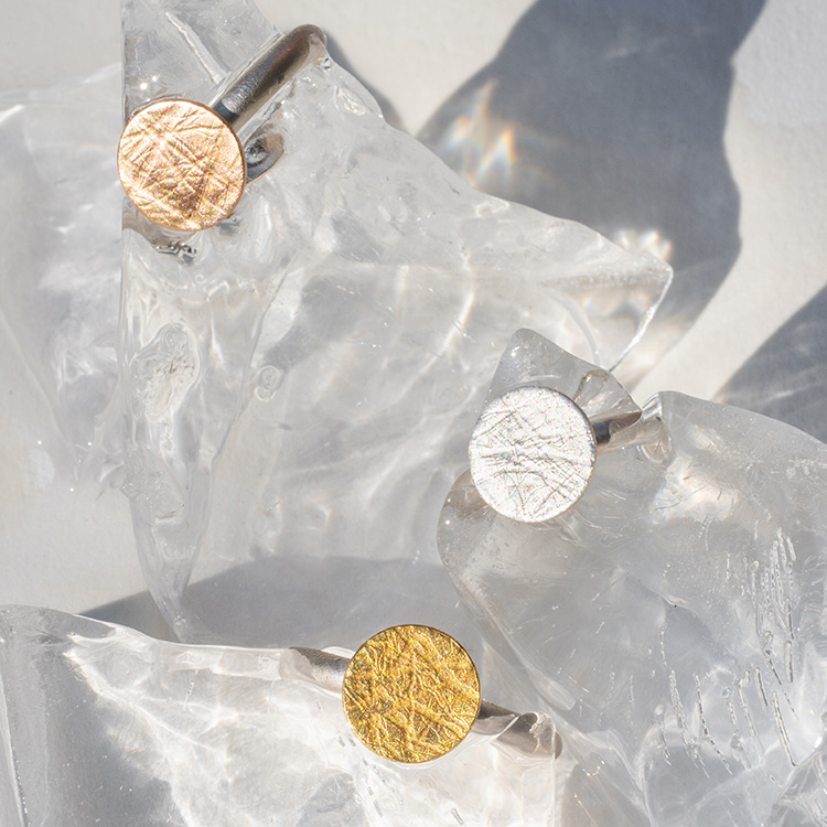 4 Ringe aus Silber mit Punkt Element mit aufgewalzter Struktur mit Gelbgold, Roségold und Silber.
